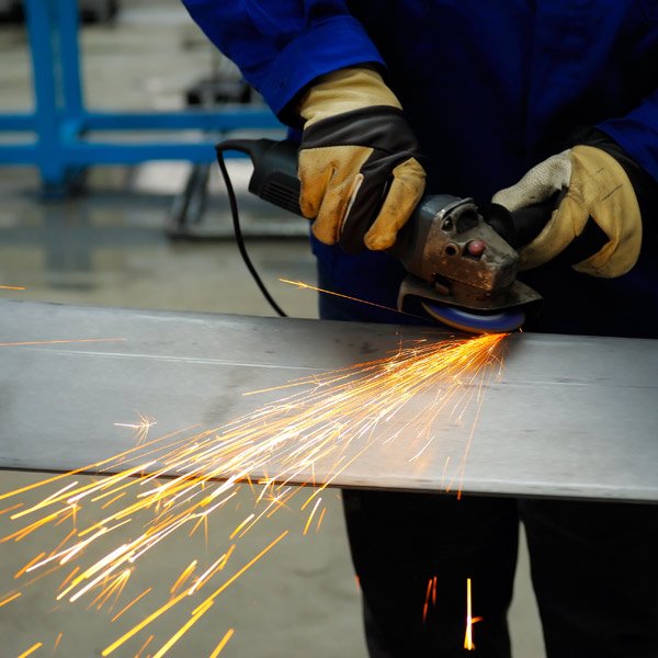 welder smoothing the edges with the help of a machine
